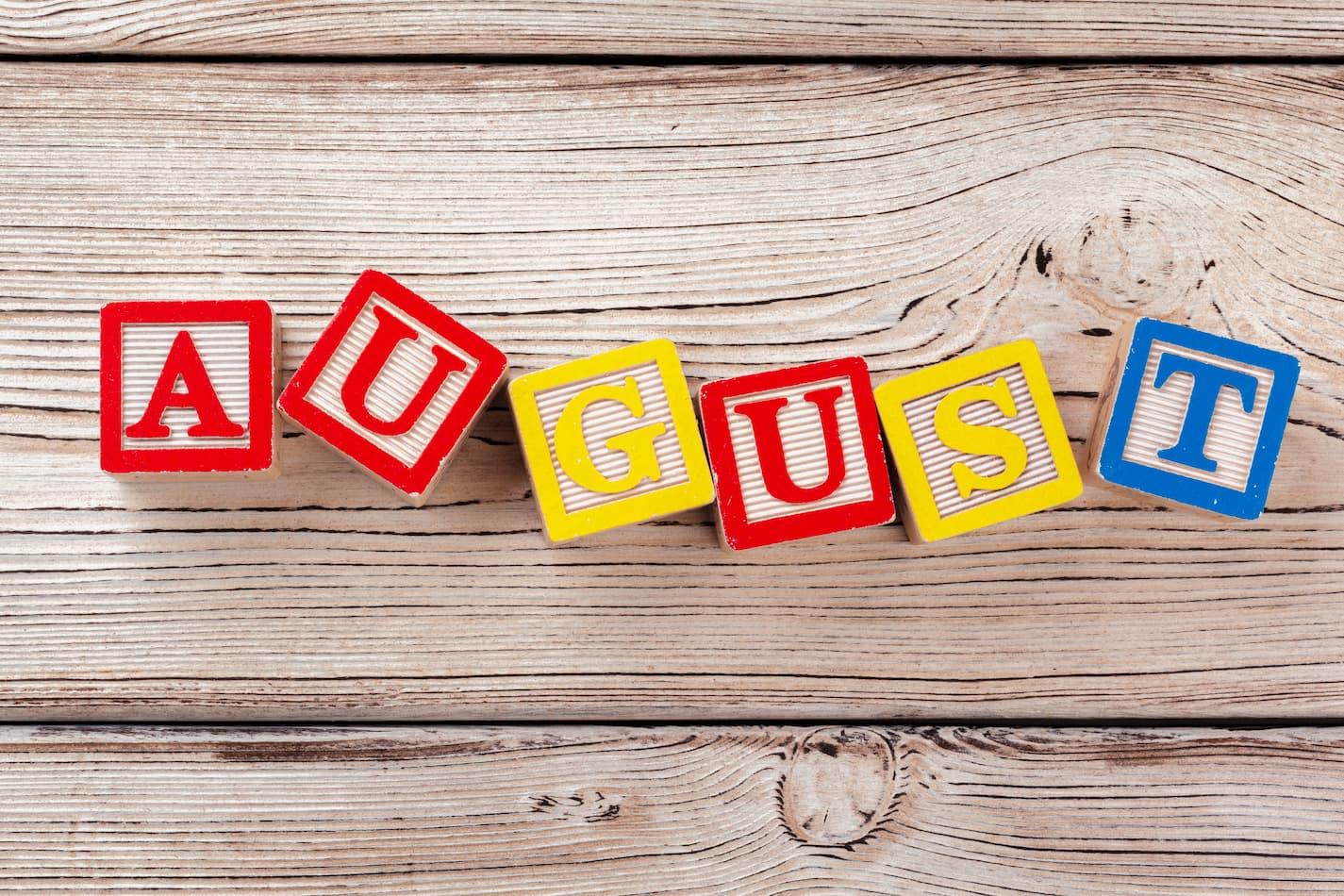 Image of blocks spelling out August on a wooden background