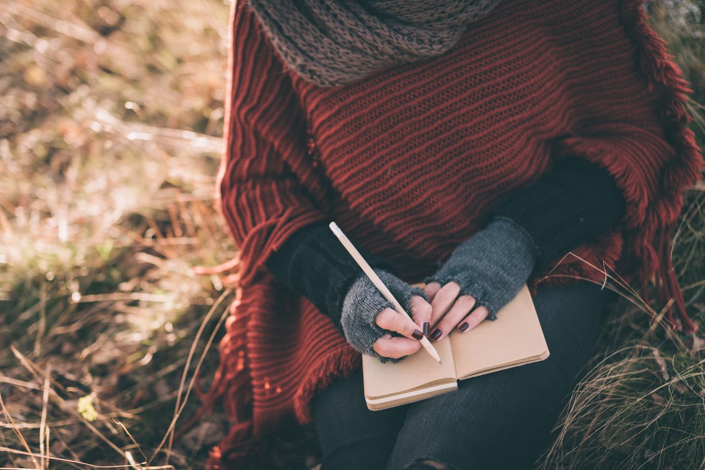 image of woman in a shawl writing in a notebook