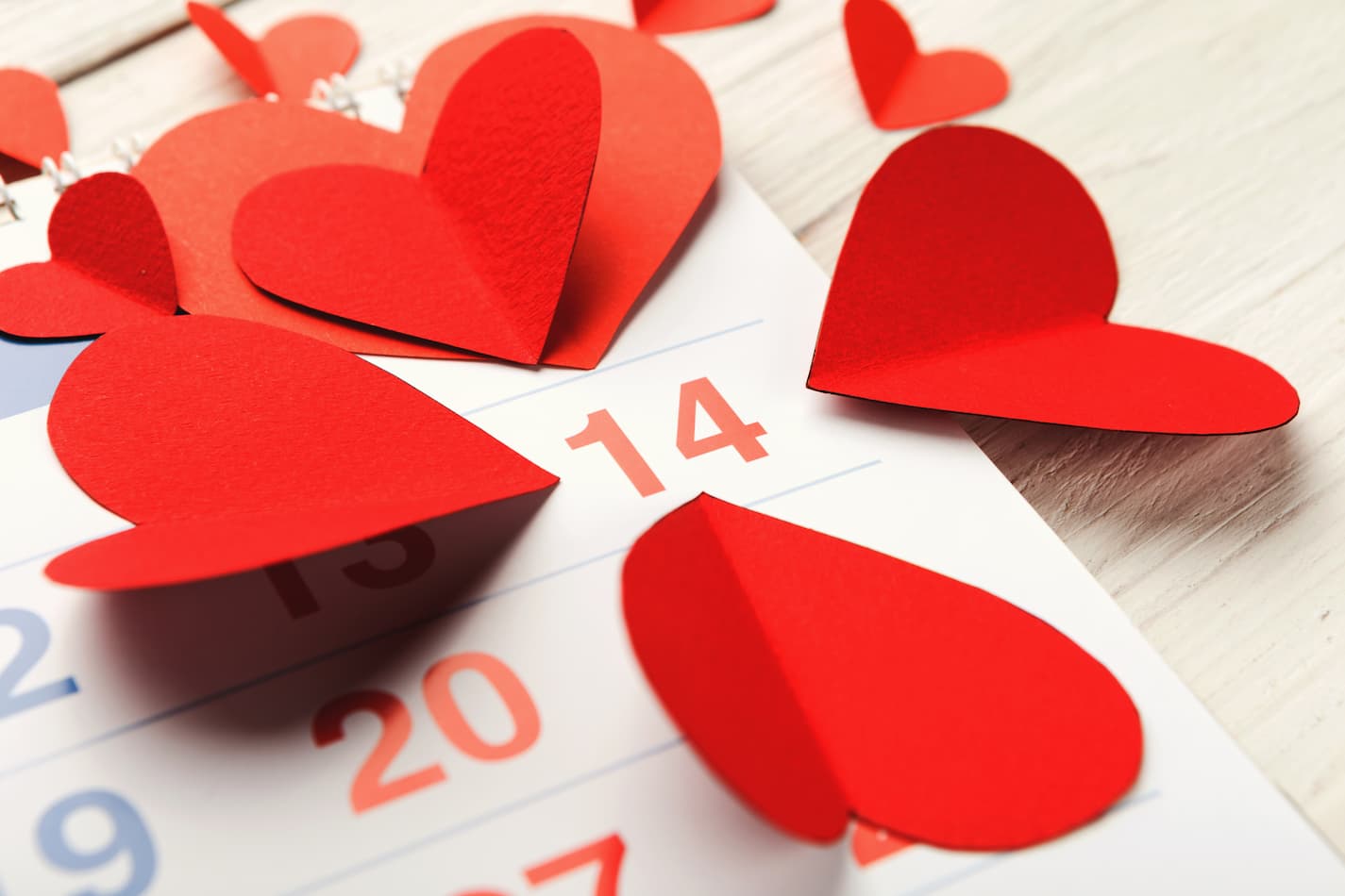 An image of cutout hearts surrounding the 14th of February on a calendar