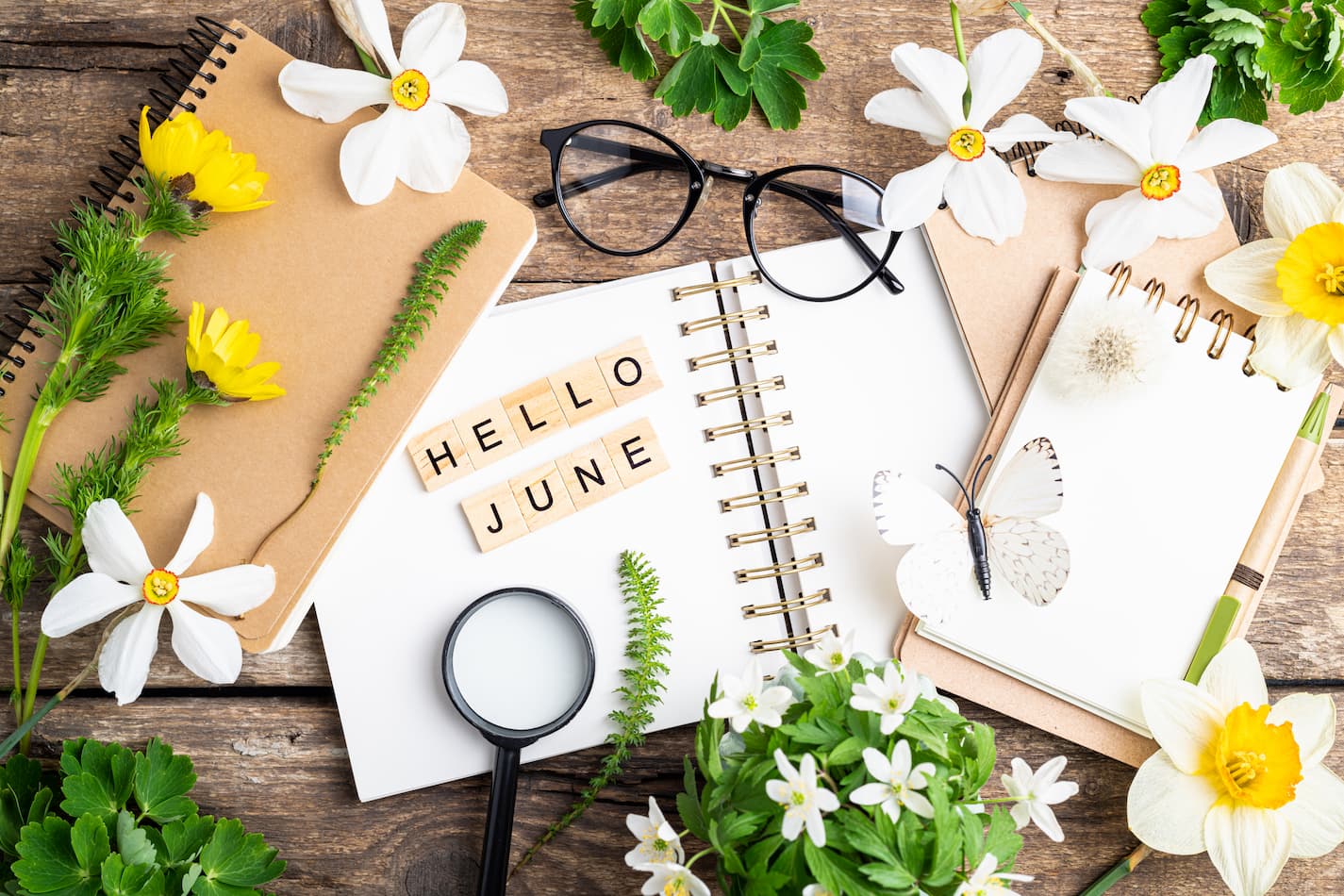 An image of open notebook with words hello June with flowers and glasses.