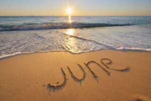 An image of word June written on beach by waves