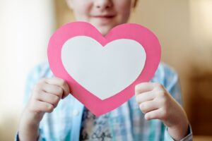 Image of child holding paper heart cutout