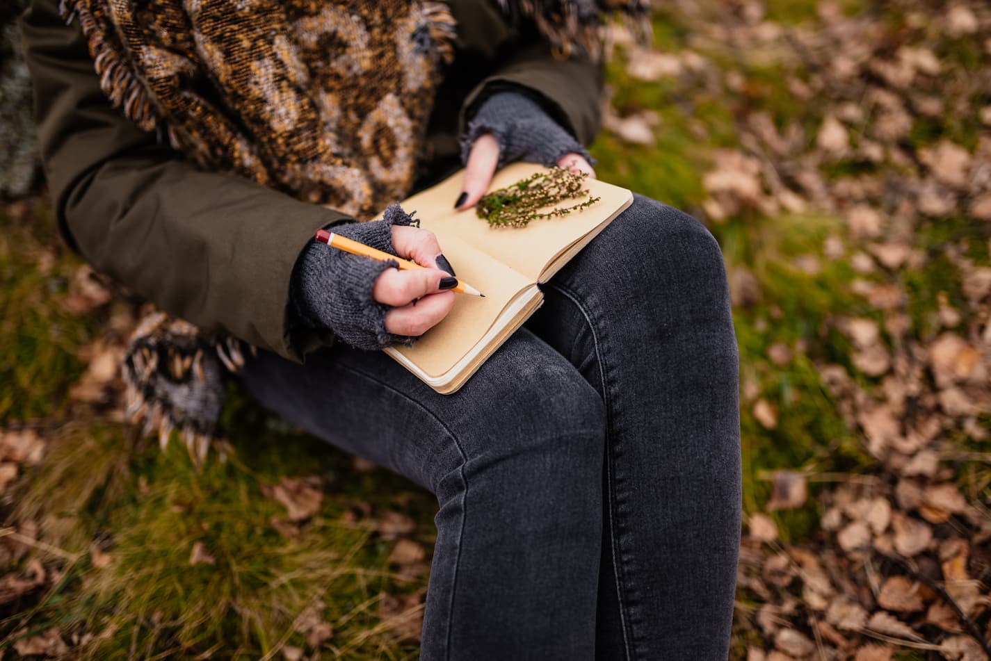 image of a woman writing in a notebook in fall