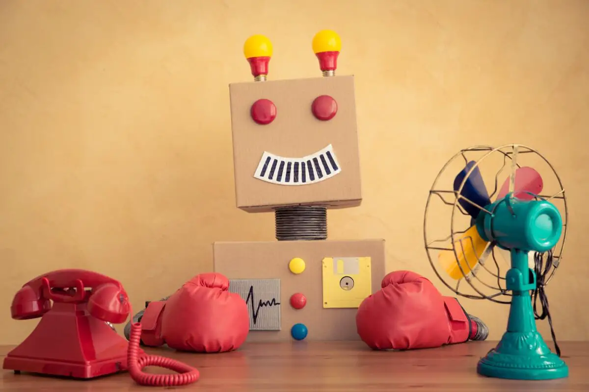 an image of a funny robot made of cardboard and random items sitting at a desk